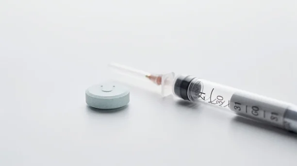 The image shows a medicine tablet and an injection pen placed on a clean white surface, representing different weight loss treatments such as those used in weight management and obesity treatment. These medications, including oral GLP-1 receptor agonists, are designed to support weight loss journeys and help manage body weight effectively.